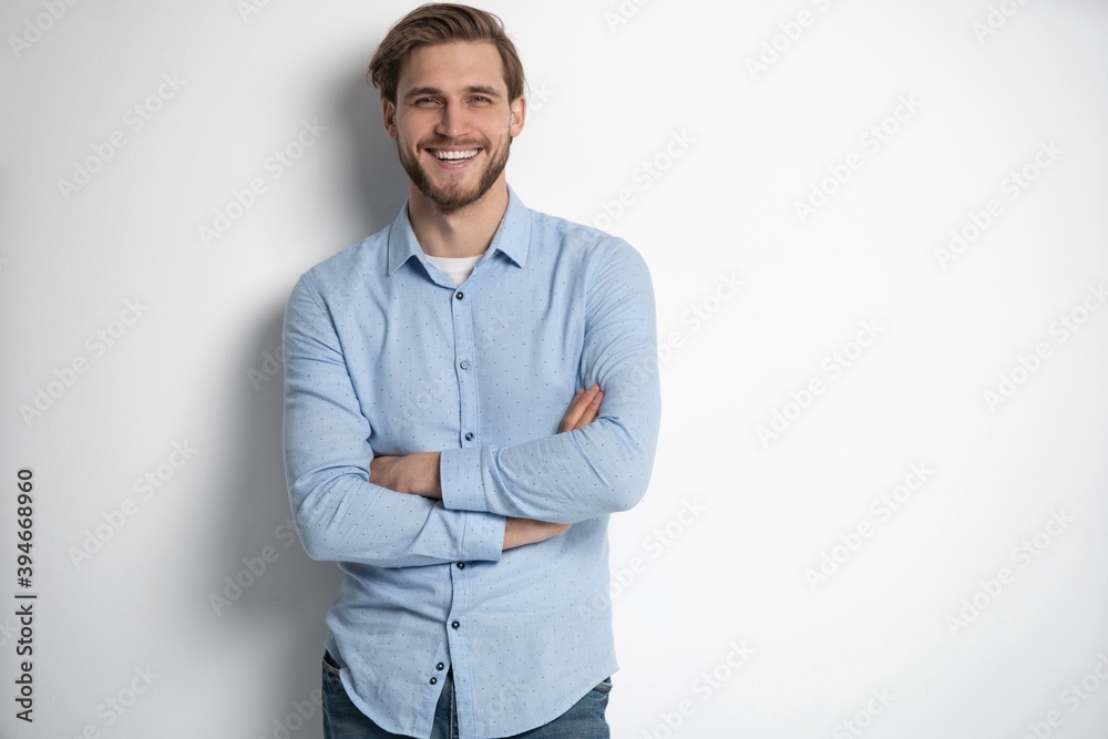 Wall mural portrait of a smart young man standing against white background. - Wall murals