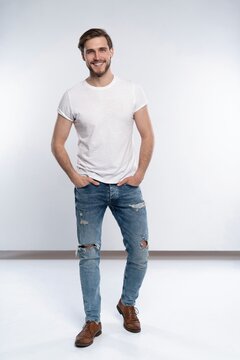 Full Length Studio Portrait Of Casual Young Man In Jeans And Shirt. Isolated On White Background.