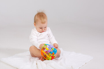 baby playing with a colorful toy isolated on a white background