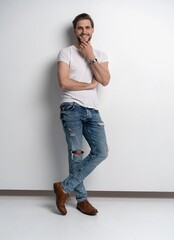 Full length studio portrait of casual young man in jeans and shirt. Isolated on white background.