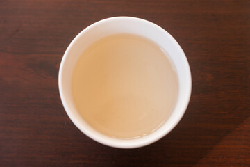 Beautiful porcelain tea cup close up shot. Hydrating pale liquor in it.
Bai Hao Yin Zhen (White Hair Silver Needle) white tea from Fujian province. Top view.