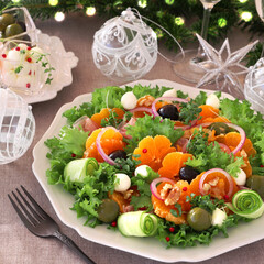 Christmas salad with tangerine prosciutto, mozzarella, olive and lettuce. fir tree background. みかんと生ハムモッツァレラサラダ