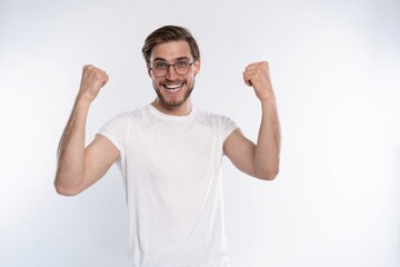 Fototapeta premium Happy winner. Happy young handsome man gesturing and keeping mouth open while standing against white background.