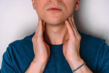 A man checks the lymph nodes on his neck.