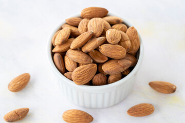 almonds in bowl - on wooden background