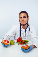 young pretty doctor with stethoscope holding fruits, healthy food care concept