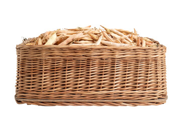 Dry bean pods in a wicker basket on a white background, isolate, close-up