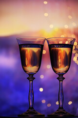 Two glasses with sparkling wine on a colorful festive background. The mood of celebration, happiness and fun.