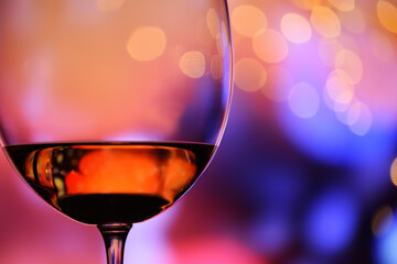 Glass with rose wine against a colorful festive background. The mood of the holiday, happiness and...