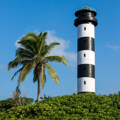 Black and white sttriped lighthouse with coconut palm at southern tip of Little Andaman island, India.