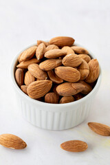almonds in bowl - on wooden background