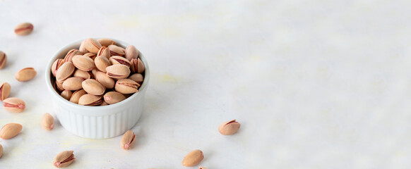 pistachios in bowl - on wooden background  - copy space