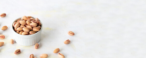 pistachios in bowl - on wooden background- copy space