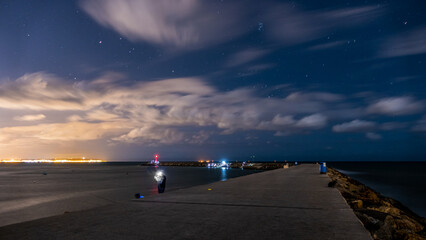 Foto nocturna de la escollera del puerto de Guardamar del Segura, España.