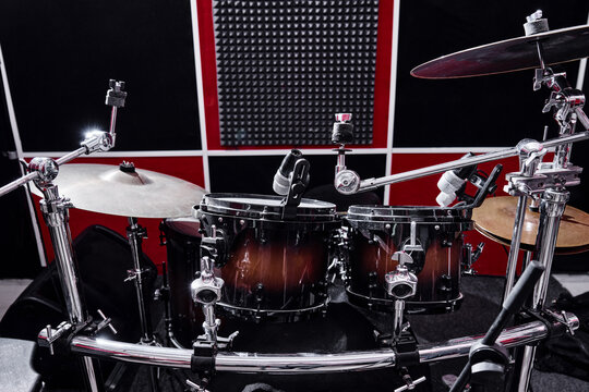 Modern professional drum kit on a rehearsal base close-up, red and black recording studio