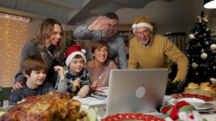 Happy and Excited family greeting their family and friends on Christmas eve using a video call. Some relatives waving and talking to a laptop screen. Social distancing, quarantine. - Powered by Adobe