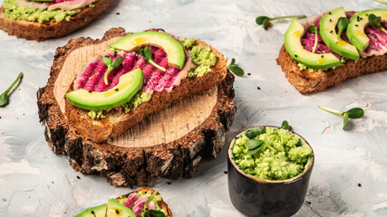 avocado and watermelon radish toasts on a light background, top view. Food recipe background. Close up