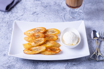 Fried bananas with honey, cinnamon, coffee and ice cream. Close-up.