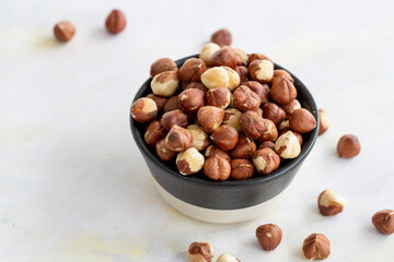 Hazelnuts in plate on white background - copy space