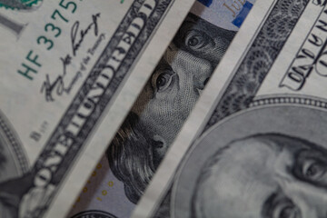 Benjamin Franklin peeking through 100 dollar banknotes