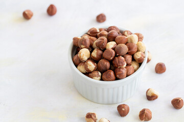 Hazelnuts in plate on white background - copy space