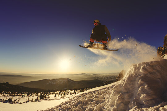 Snowboarder jumping through air with deep blue sky in background