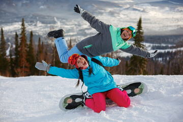Girls snowboarders having fun and posing on the slope of a ski resort.