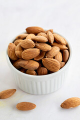 almonds in bowl - on wooden background