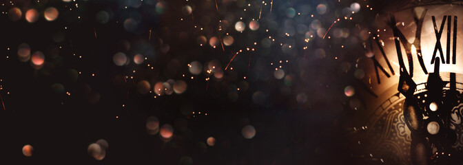 Illuminated clock on new years night sky. Abstract dark bokeh background with illuminated clock...