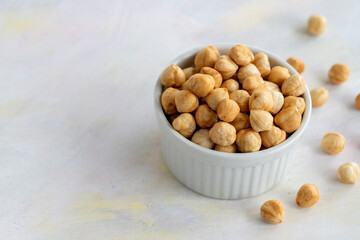 Hazelnuts in plate on white background - copy space