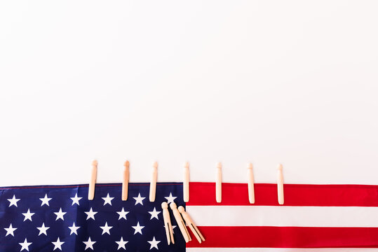 American flag fastened with clothespins on a white background, copy space for text.