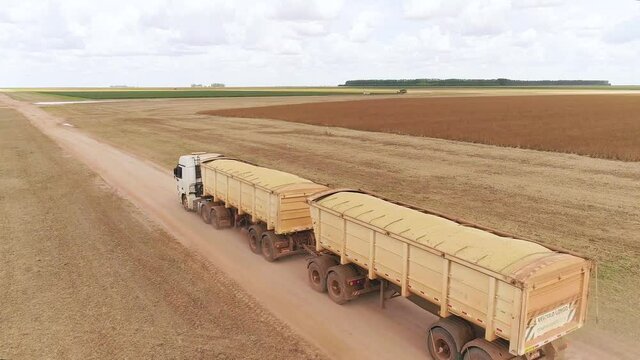 Agribusiness - Aerial image of a truck transporting soybeans, a truck loaded with grain. Harvest being transported to the silo - Agriculture