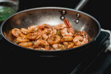 Shrimp on frying pan. Thermal processing of food. Electric cooker in a restaurant