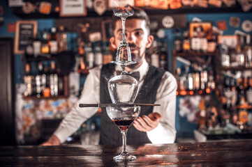Barman formulates a cocktail behind the bar