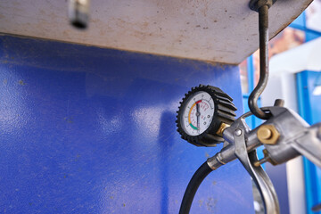 close-up. gun with pressure gauge, check tire pressure yourself
