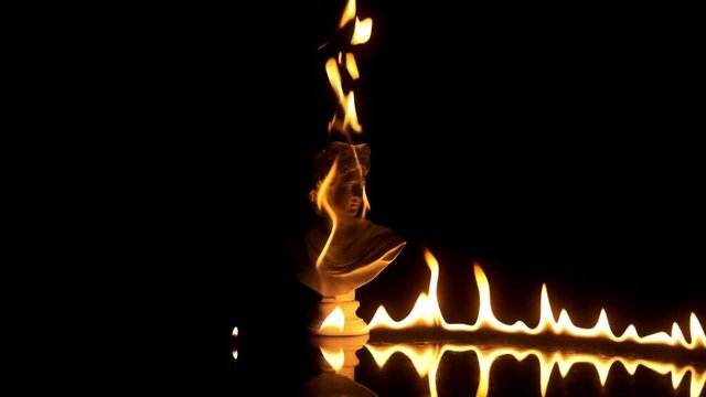 Intro footage of burning statue in slow motion
