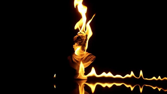 Intro footage of burning statue in slow motion