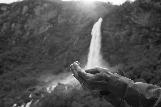 Optical Illusion Of Cropped Hands Holding Waterfall