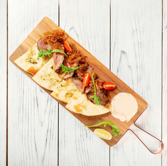 Homemade Italian Focaccia with meat and tomatoes on a rustic wooden background.