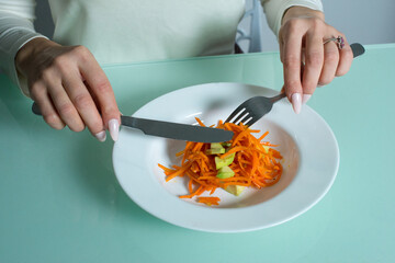 Girl sits and eats a delicious and healthy salad.