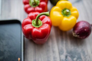Red and yellow bell peppers on a wooden table