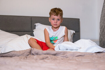 Boy sitting in the bedroom in pajamas