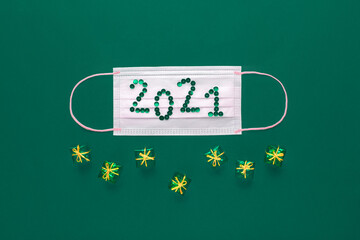 Postcard for New Year or Christmas. Surgical face shield with 2021 numerals and small bowknot gift...