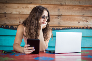 Young crazy hipster talking on the mobile smart phone, using tablet and looking on laptop. Internet connection, networking. Device electronics gadget concept