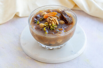 Traditional Turkish Dessert Aşure or Noah's Pudding with ingredients on white in stylish bowl: Aşure 