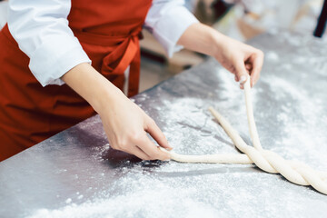 Baker showing sheet with bread ready to be baked
