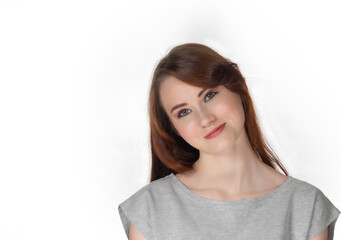 Obraz premium Portrait of a young girl with brown hair on a white background