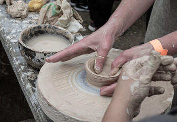 Clay modeling training on a potters wheel in the open air. Art, creativity. Modeling clay, cultural traditions, hobby