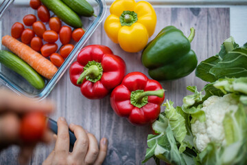 Fresh and colorful bell peppers and other vegetables on wooden table