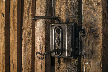 Close up of vintage key on wooden cellar door